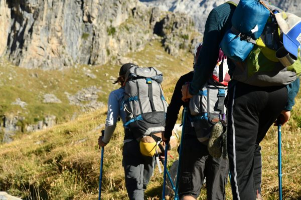 Hiker using trekking poles climbing steep trail with focused breathing posture