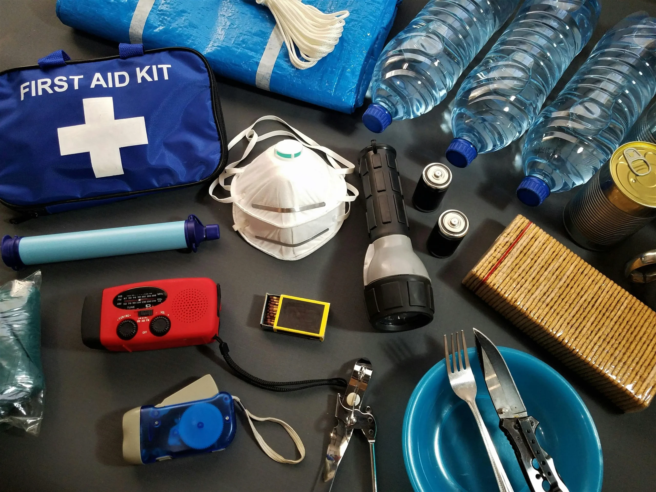 Hiking Safety Tips Every Beginner Needs 6 Essential hiking safety gear laid out including first aid kit, whistle, headlamp, map, and emergency blanket